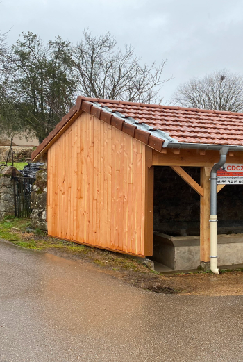 Abri en bois avec toiture en tuiles rouges et gouttières