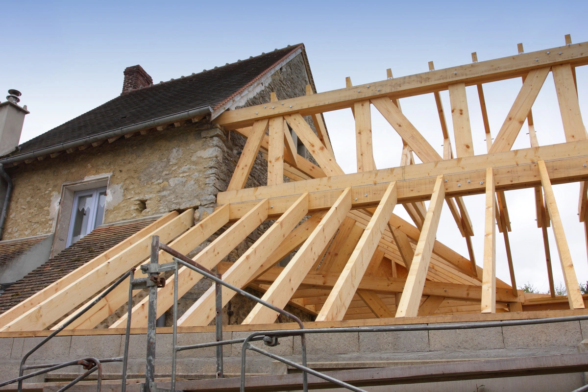 Charpente en bois en cours de construction pour la rénovation d'une toiture d'une maison ancienne