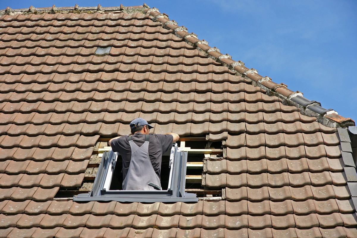 Installation de fenêtre de toit par un professionnel sur une toiture en tuiles