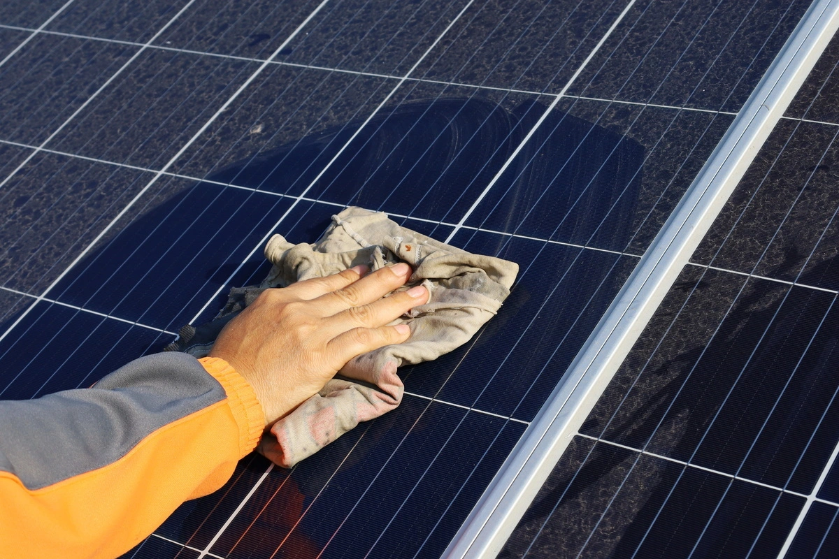 Nettoyage d'un panneau photovoltaïque sur une toiture pour maintenir l'efficacité de la production d'électricité solaire