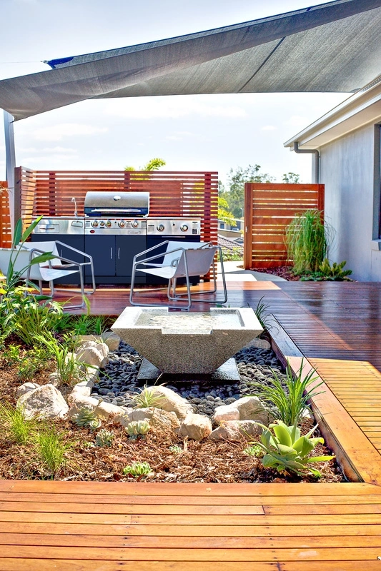 Terrasse de toit en bois avec coin barbecue et jardin paysager, offrant un espace de vie extérieur élégant et fonctionnel